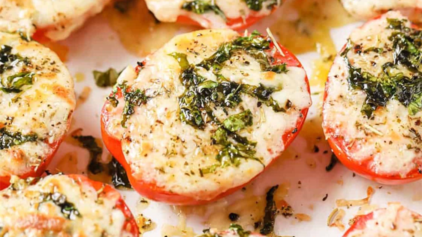 Baked tomatoes with Parmesan and mozzarella cheese garnished with parsley.