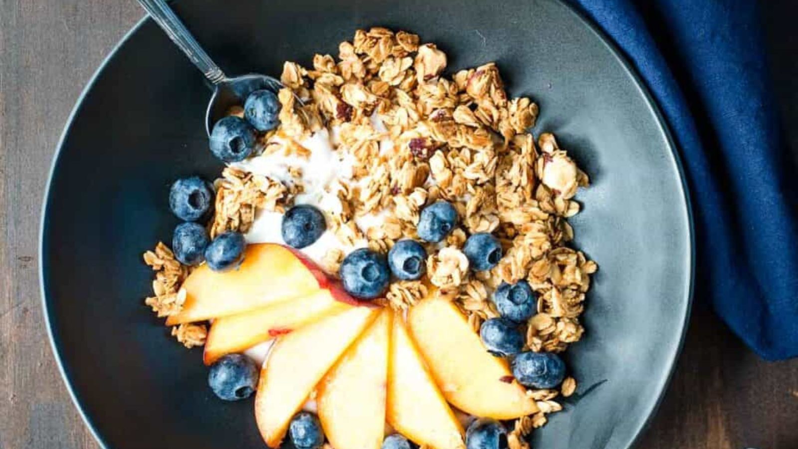 Granola on a tray next to servings of granola and fresh fruit.