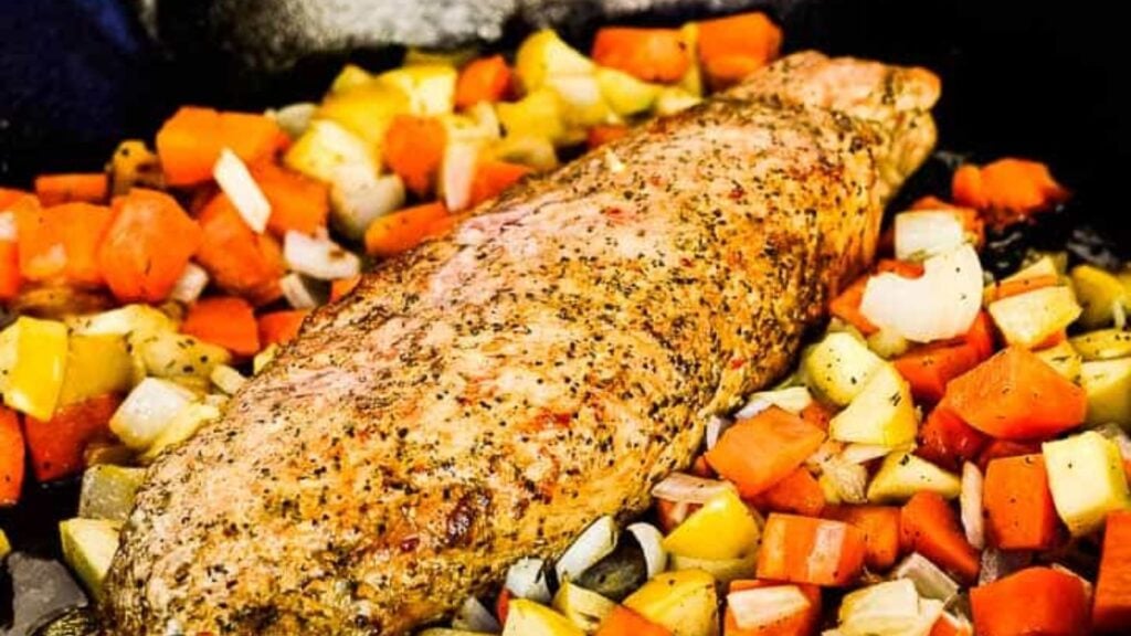 Cooked pork and vegetables in a pan.
