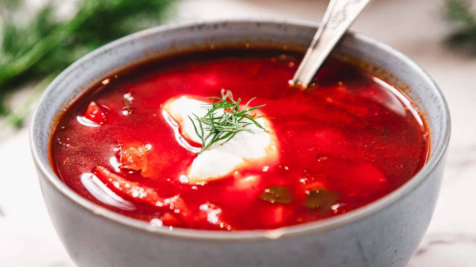 Un bol de borscht garni de crème aigre et d'aneth frais.