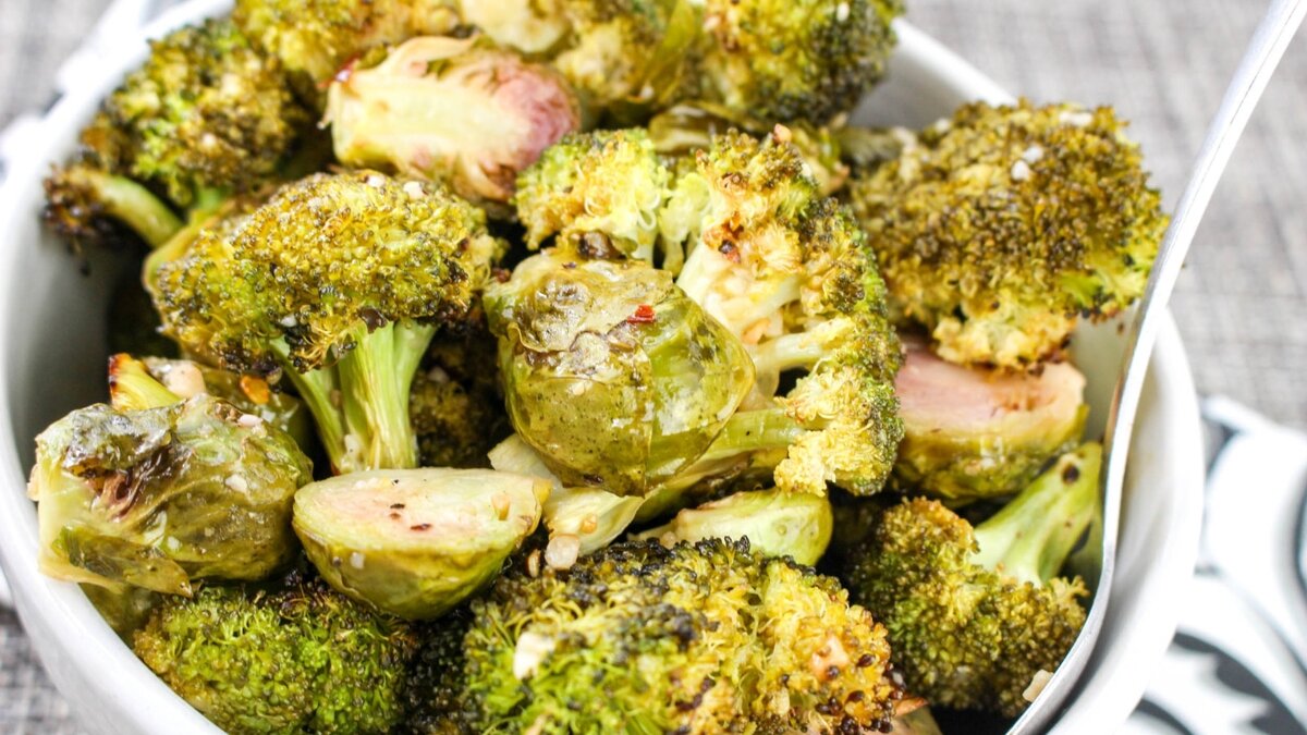 A bowl filled with roasted Brussels sprouts and broccoli.