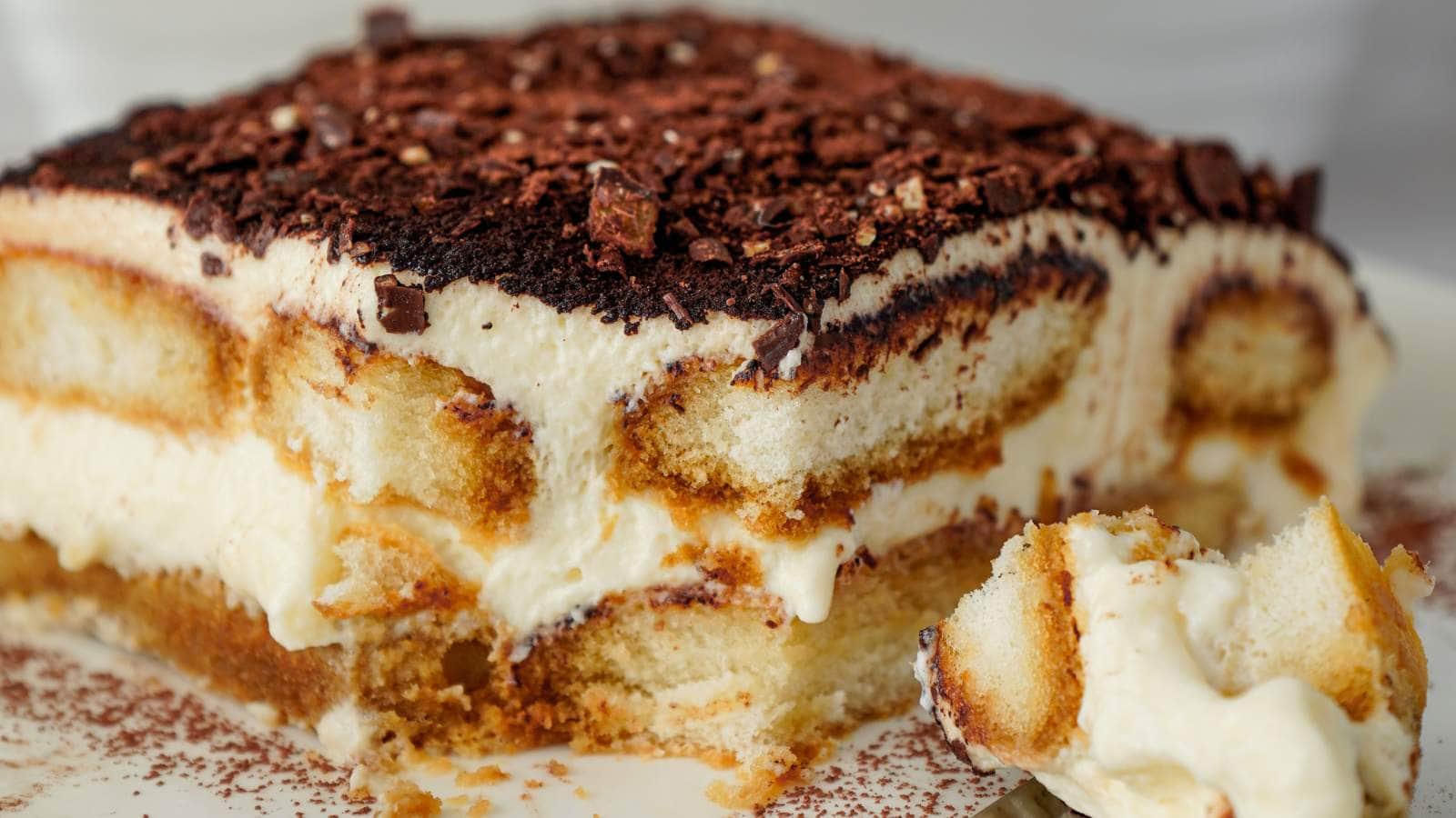 Close-up of a slice of tiramisu with layers of coffee-soaked ladyfingers and mascarpone cream.
