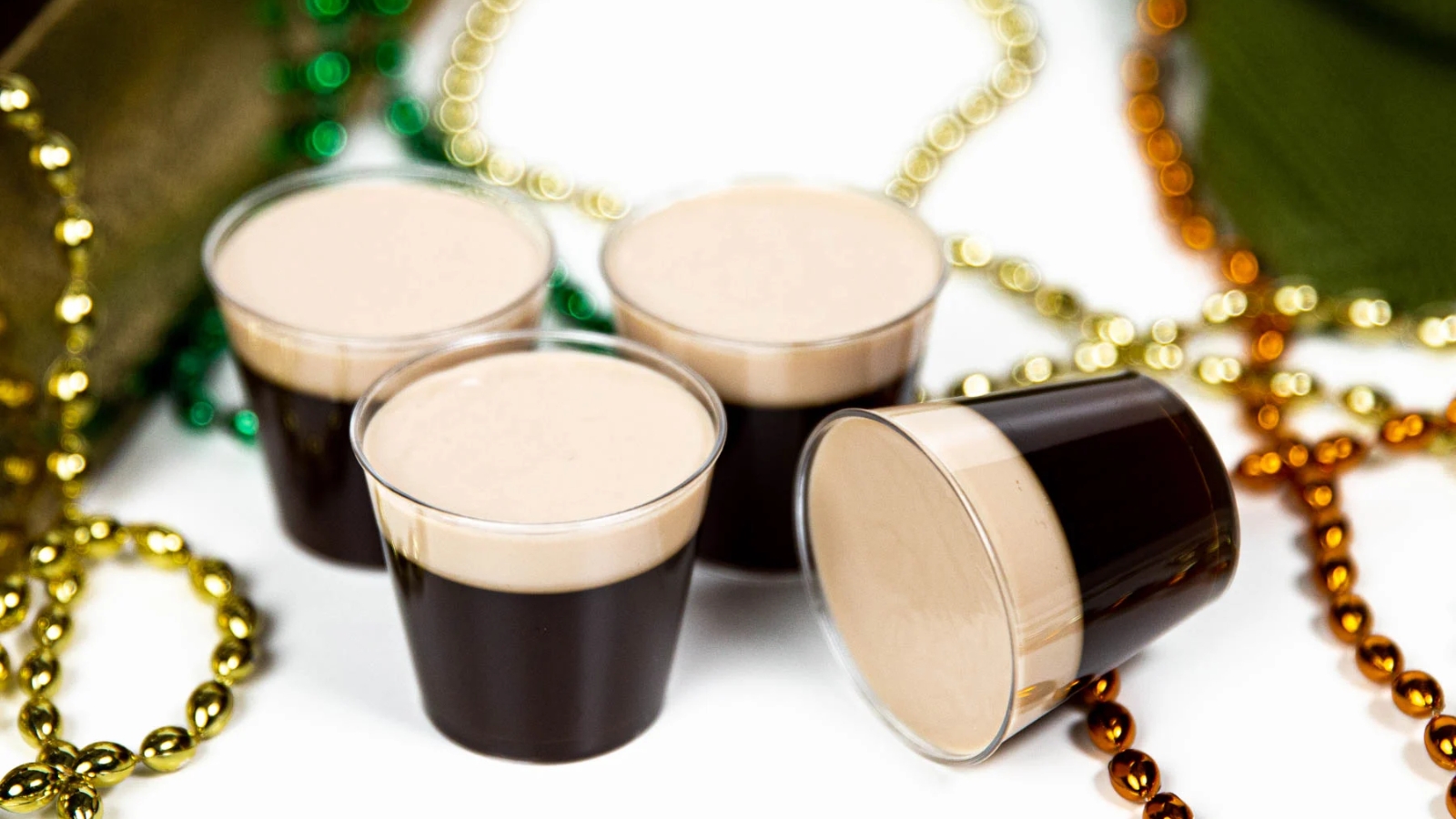 Baby Guinness Irish coffee jello shots layered with dark coffee gelatin and creamy topping.