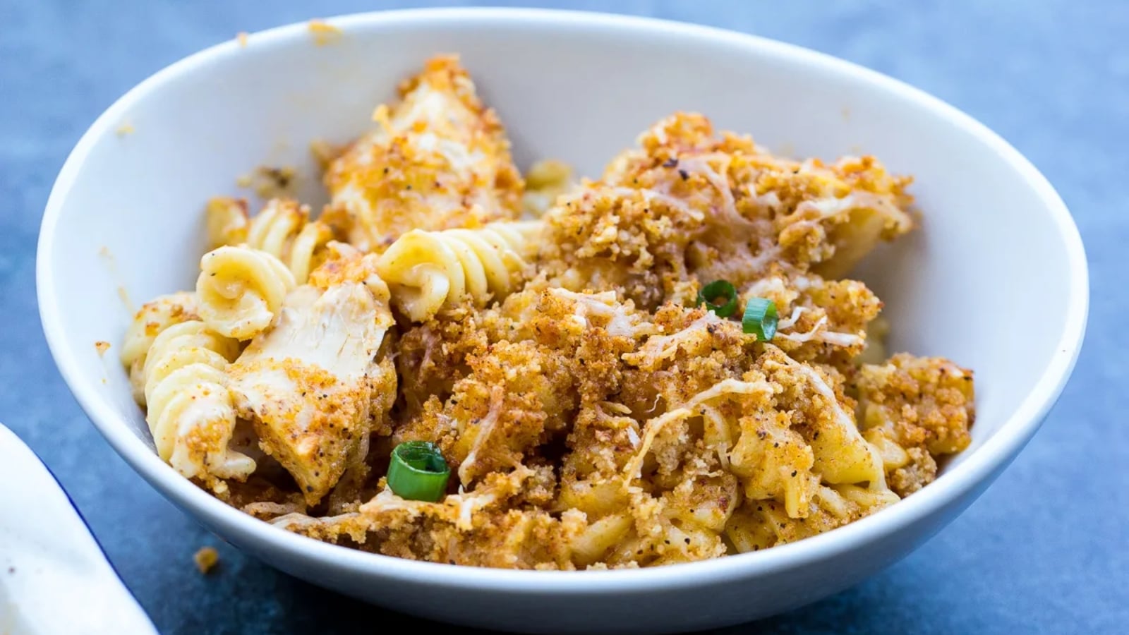 Grilled chicken layers over creamy mac and cheese for a quick, complete dinner.