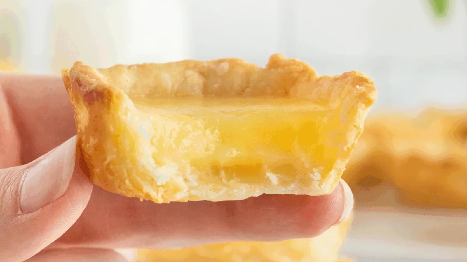 Lemon tarts with smooth lemon curd filling in pastry shells.