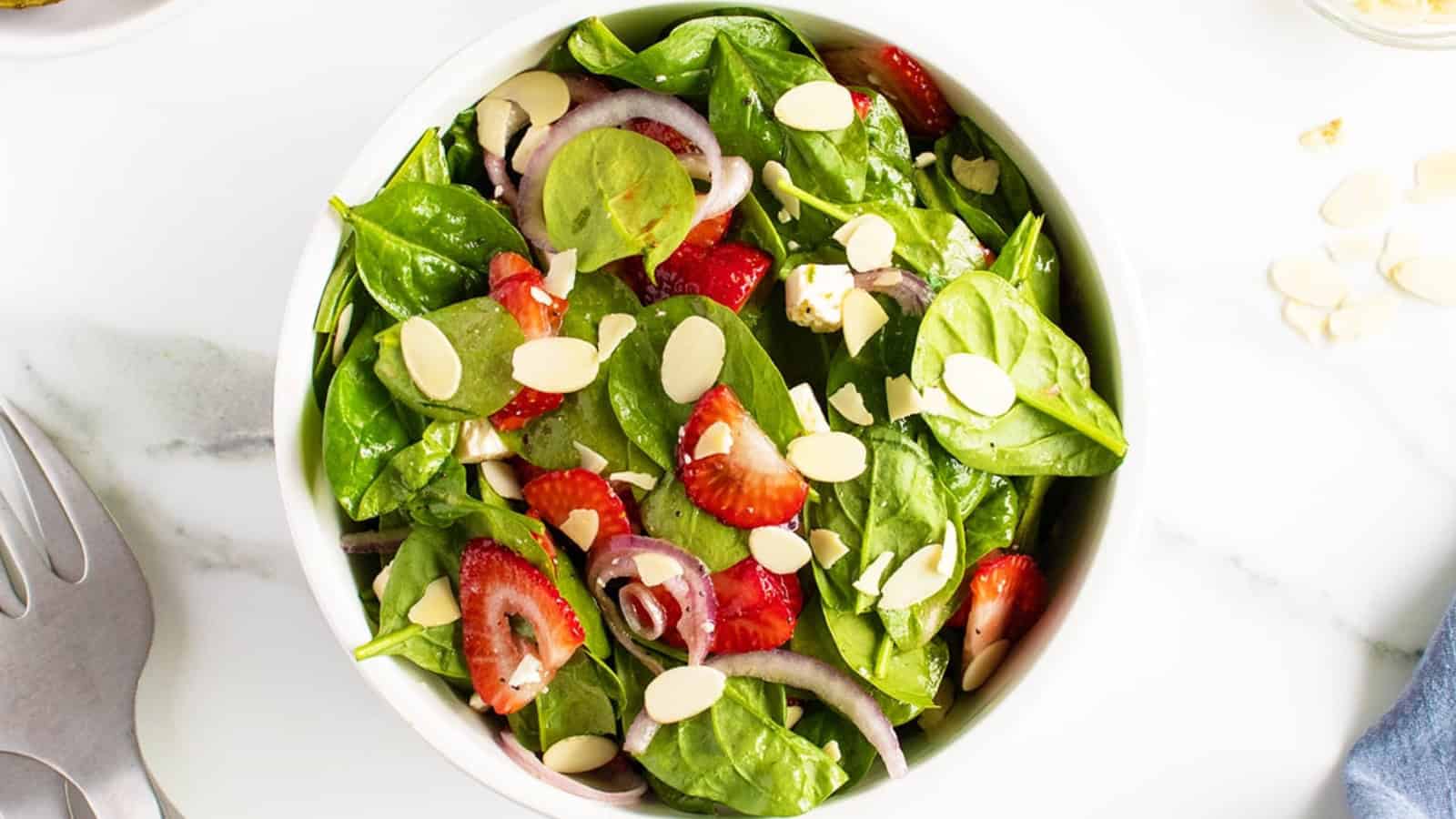 Strawberry spinach salad with fresh strawberries, spinach, and toppings in a bowl.