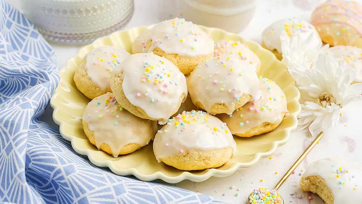Italian Easter cookies with vanilla glaze and colorful sprinkles on a plate.