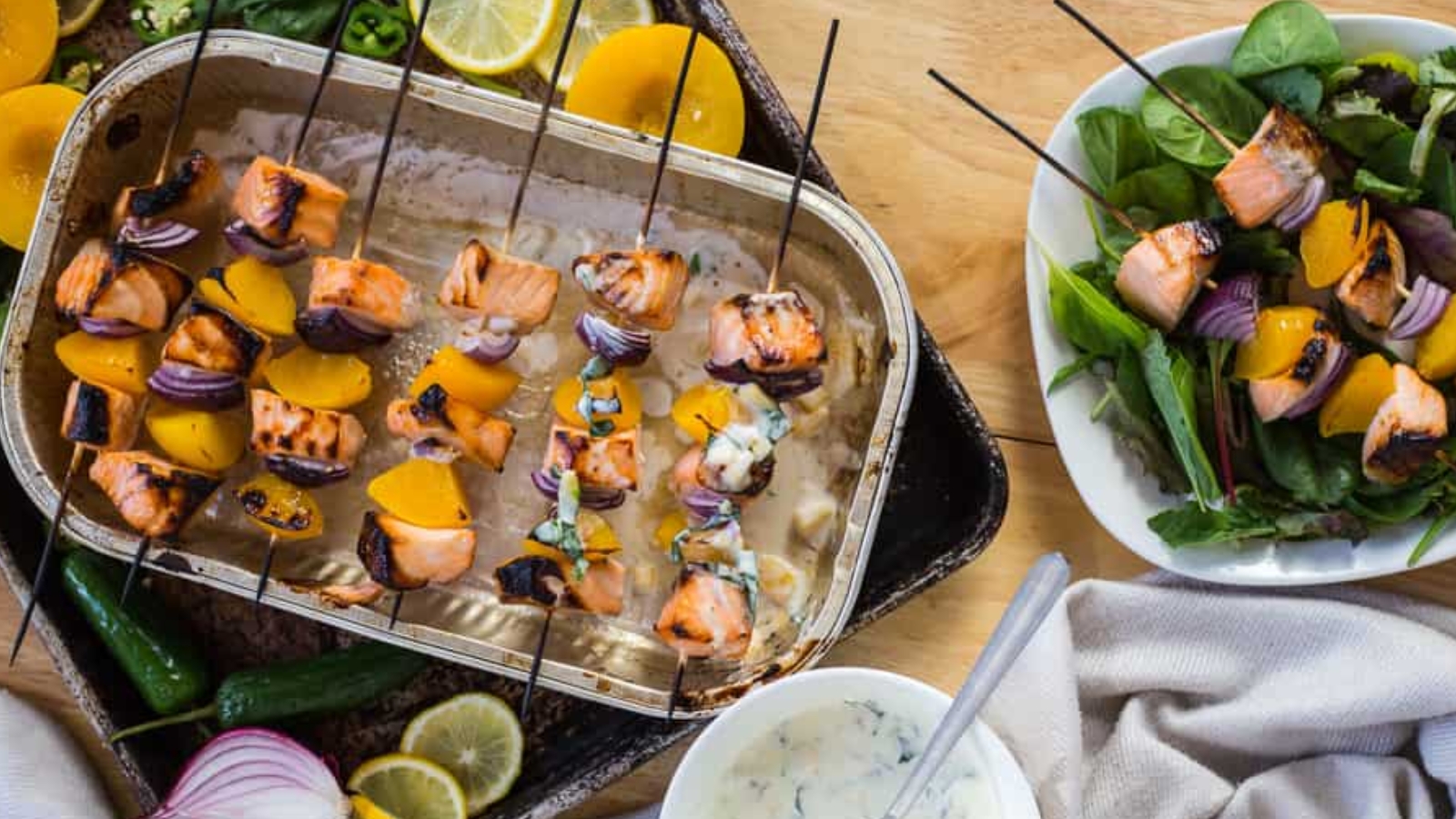 Side view of salmon skewers with more in background.