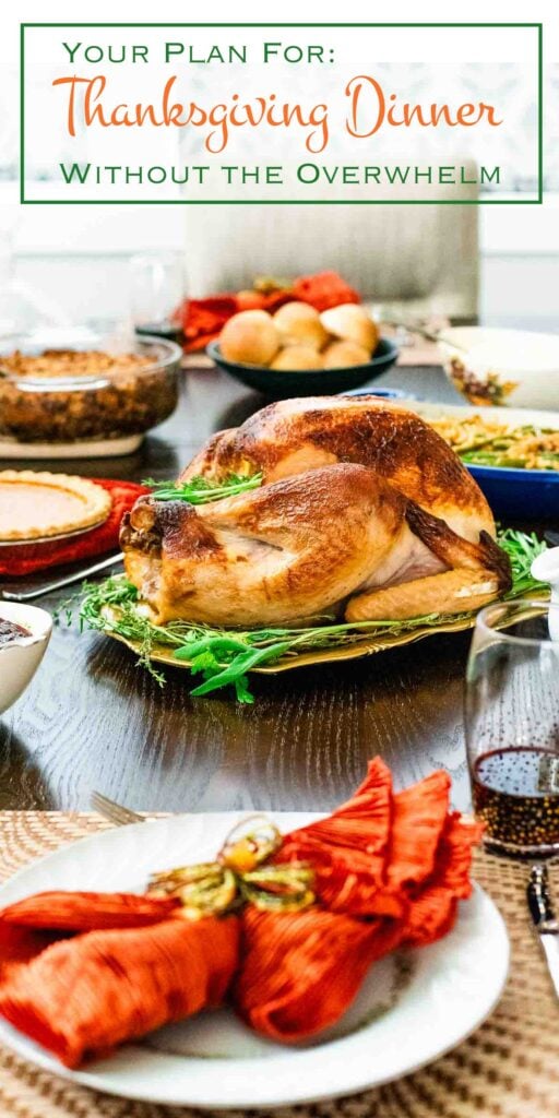 A roasted turkey on a platter surrounded by other thanksgiving menu dishes on a dining table, with the text “Your Plan For: Thanksgiving Dinner Without The Overwhelm” at the top.